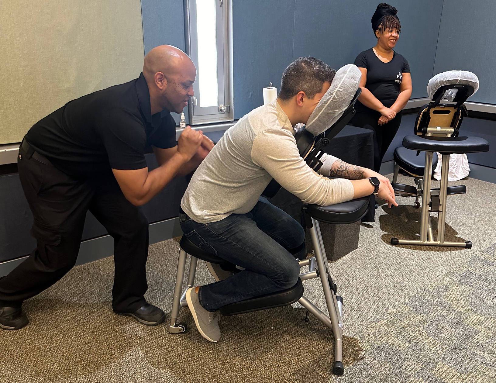 Massage therapist giving man a chair massage